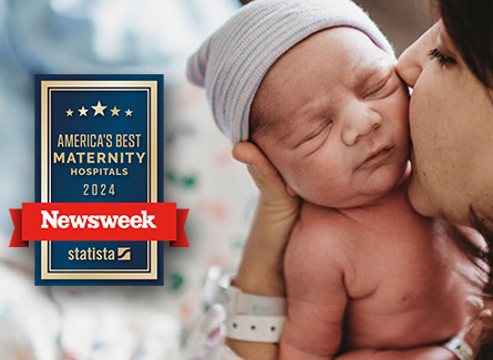 A woman kissing a newborn child