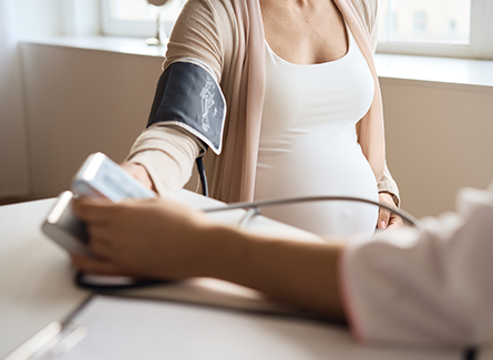 Pregnant woman having blood pressure checked