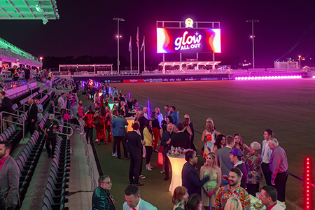 people on the field with Glow All Out sign
