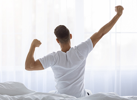 Man stretching in bed