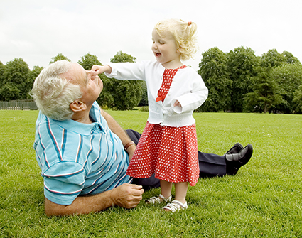 Man with granddaughter playing in field