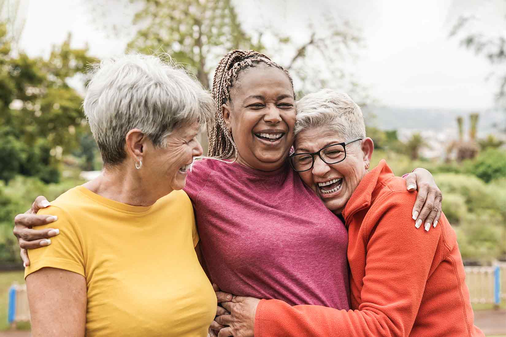 Three women laughing and hugging