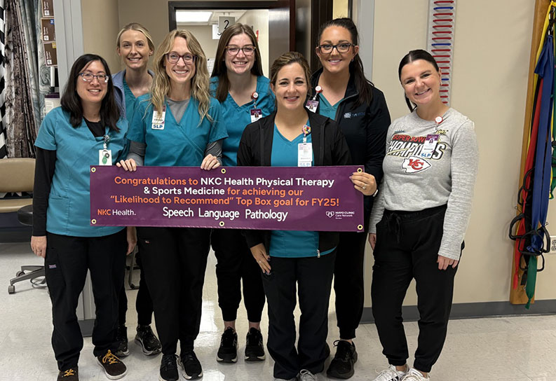 Speech Language Pathologists holding top box banner