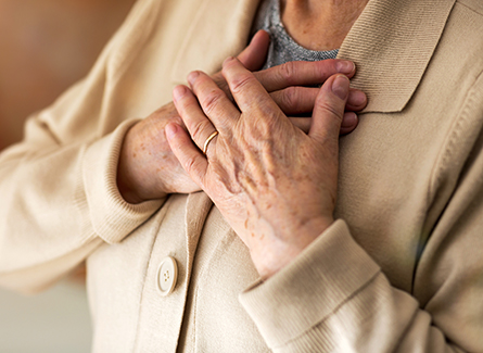 Close up of senior woman with hands over heart