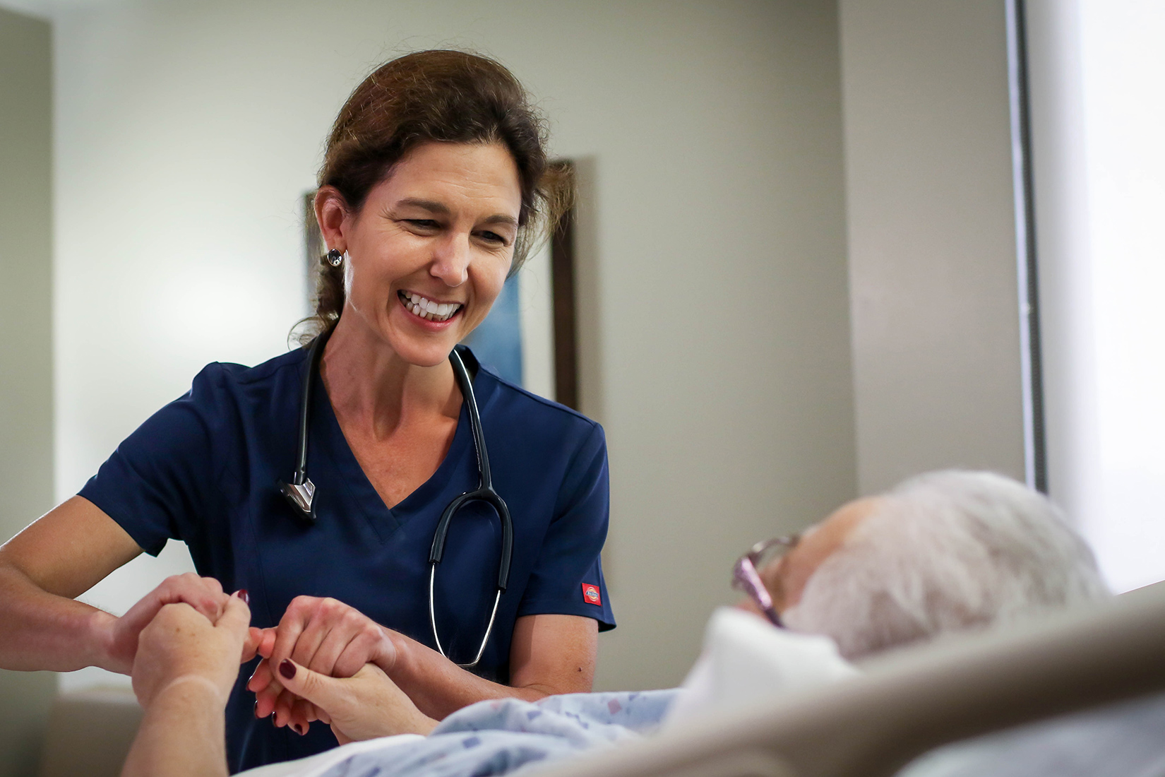 Nurse holding hands with patient
