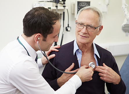 Doctor checking senior patient with stethoscope