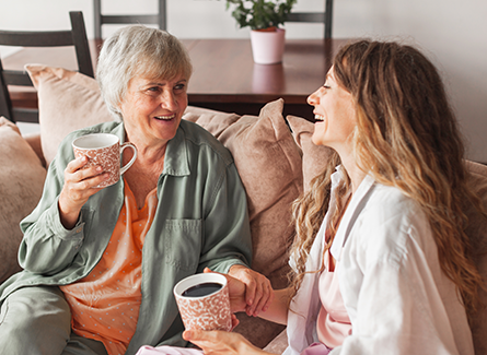 Older woman sitting with daughter on couch