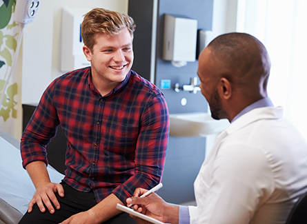 Younger man speaking wit his doctor