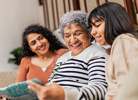 Three generations of women looking at photo album