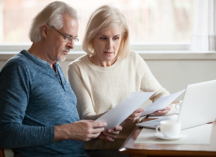 Couple looking at forms and a laptop