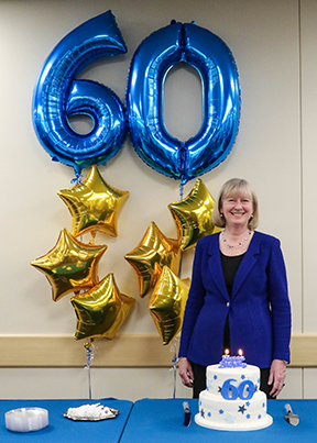 President and CEO Peggy Schmitt with cake and balloons