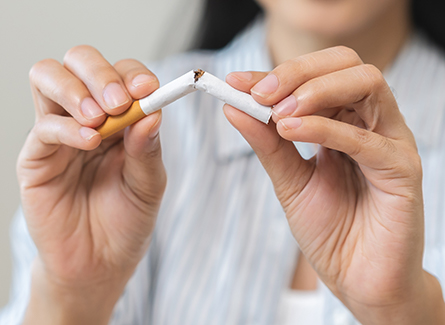 Woman breaking cigarette in half