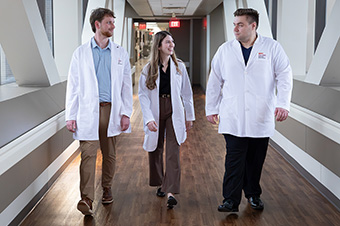 Group walking down hallway in white coats