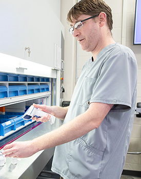 Pharmacy tech scanning vials