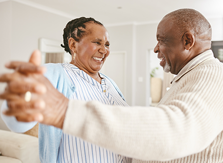 Older couple dancing together at home