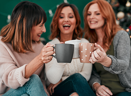 Three friends drinking out of mugs
